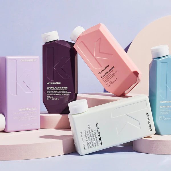 KEVIN.MURPHY hårplejeprodukter i farverige flasker, stillet op mod en pastelbaggrund.