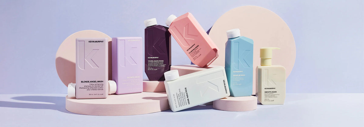 KEVIN.MURPHY hårplejeprodukter i farverige flasker, stillet op mod en pastelbaggrund.